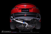 Tomei Expreme Titanium Exhaust System for RX-8 SE3P Early Model 13B-MSP showcased under a red RX-8 car.
